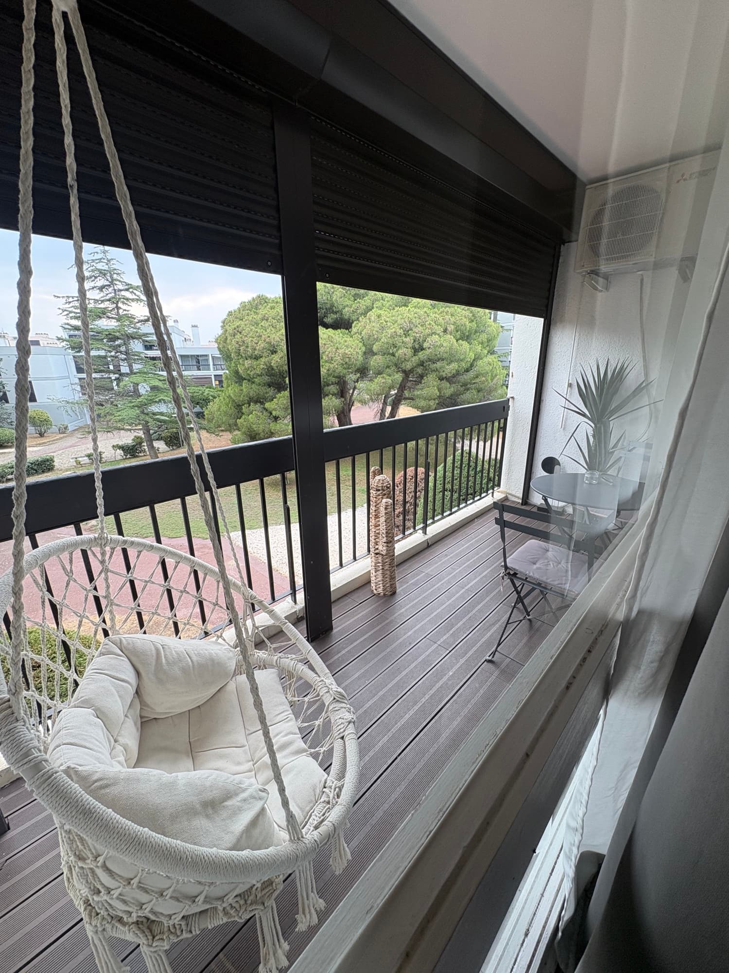 Terrasse avec fauteuil suspendu et vue parc